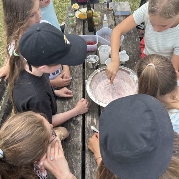 Schülergruppe, die Himbeerjoghurt zubereitet