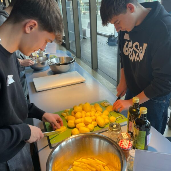 Zwei Schüler schneiden Kartoffeln.